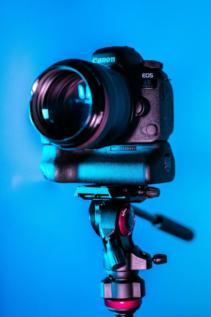 pexels-photo-1787235-1787235 Close-up of a DSLR camera on a tripod with a blue background.